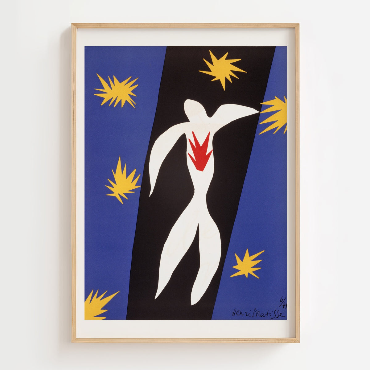 A framed art print featuring a stylized white human figure with a red chest shape, set against diagonal blue and black panels with yellow starburst motifs, hung on a light wall.